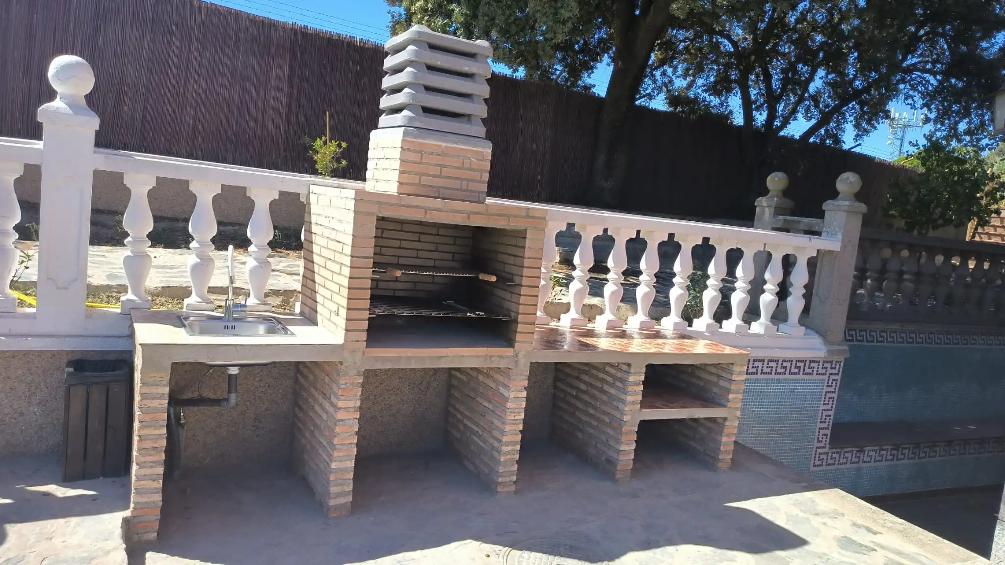 Gigante barbacoa de obra con grifo y zona de mesas para 25 personas