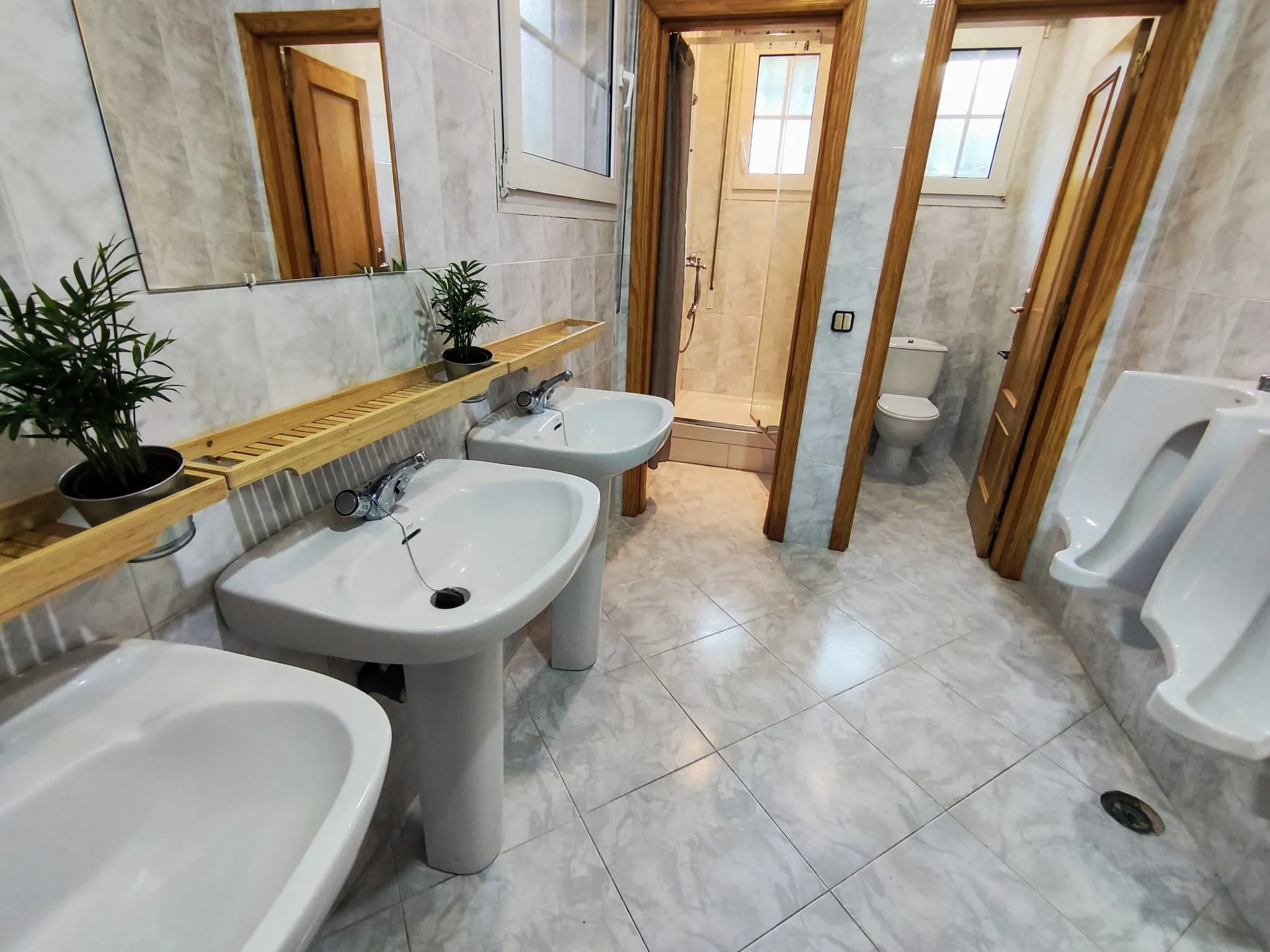 Baño con tres lavabos, dos urinarios de pie, wc y ducha. Gel, champú y toallas incluidas