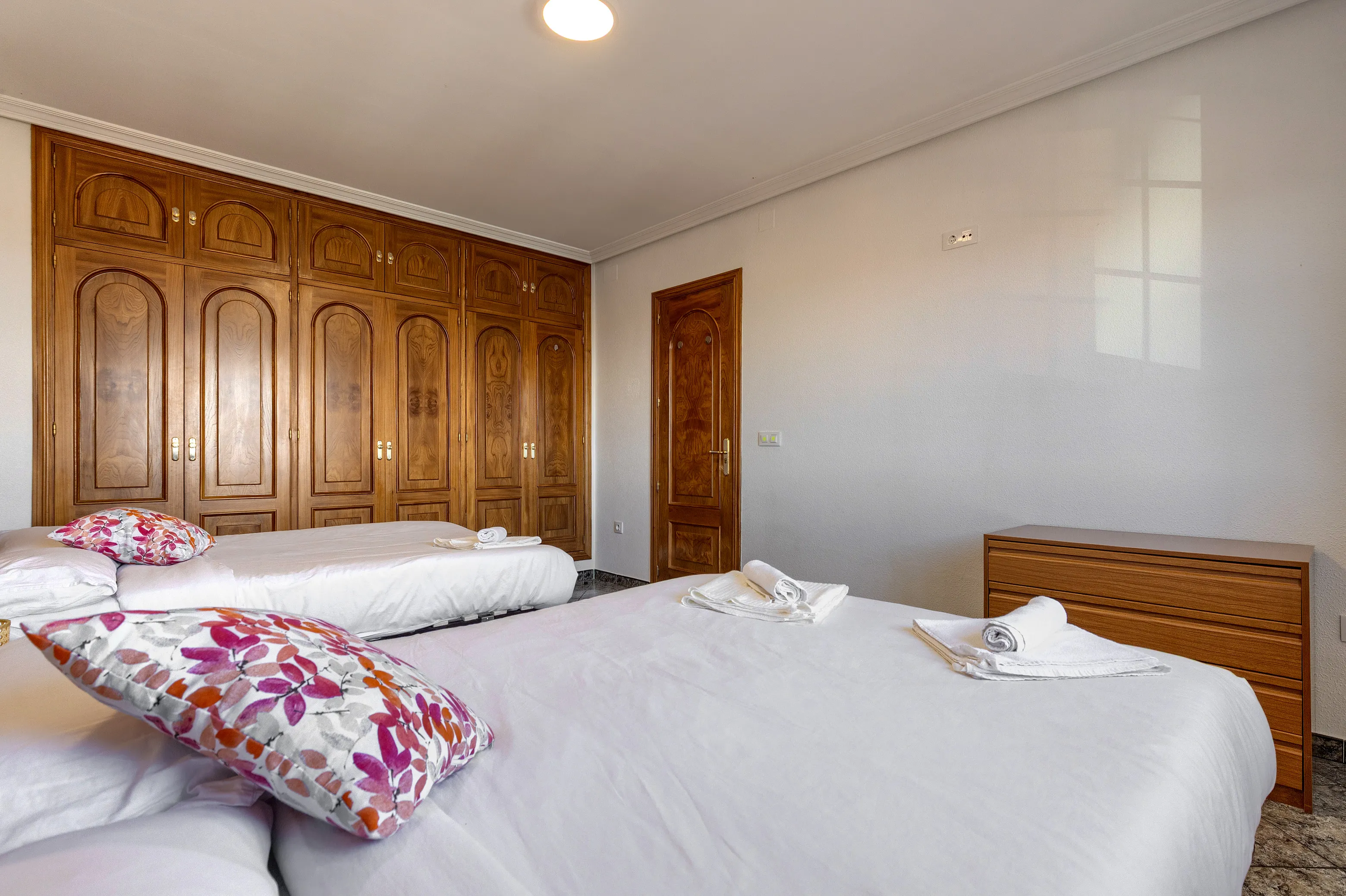 Habitación con dos camas dobles, armario empotrado, cómoda y AC